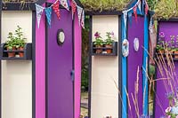 Colourful beach huts with wildflower green roofs and bunting. Fun on Sea, RHS Hampton Court Palace Flower Show, 2017. Design: Tony Wagstaff.
