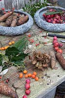 Materials and tools for making a wreath, including Hydrangea dried flowers, rosehips, crab apples, pinecones and foliage. Styling by Marieke Nolsen.
