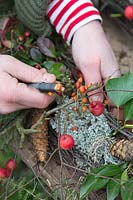 Woman wiring berries to the rustic wreath. Styling by Marieke Nolsen. 