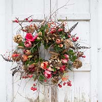 Floral wreath with Hippeastrum, crab apples, pinecones, dried hydrangea flowers. Styling: Marieke Nolsen