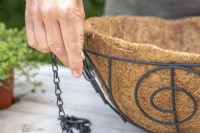 Woman unclipping chain from plant hanger