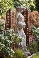 Rusty metal obelisks and a woman statue.