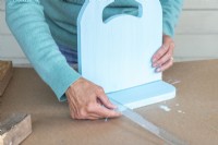 Woman measuring the distance from the edge of the base board to the centre