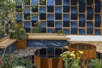 The Fashion Footprint Garden. Two Corten steel barrels mirror the planting of achilleas, scabious and burnet.