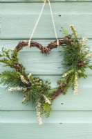 Woven heart wreath with Erica - heather flowers, evergreen foliage and Hedera - Ivy -berries