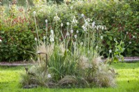  Island bed of Carex and Molinia ornamental grasses with glass sculpture.