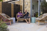 Couple seated on patio by house