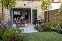 Couple sitting on patio in contemporary garden