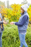 Woman recieving a small pot of Pansies from another person