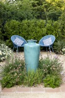 Tall ceramic container water feature in suburban garden