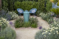 Contemporary gravel garden in suburban garden with tall ceramic container water feature