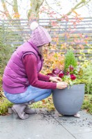 Woman covering any visible compost with moss