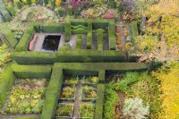 View over mature clipped hedges of Yew containing several distinct garden rooms; image taken with drone. November. Autumn.