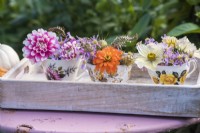 Posies of mixed flowers in teacups on white tray - Dahlias, Asters, Cosmos and Nigella seedpods