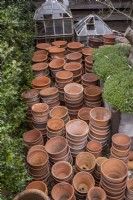 Pile of many terracotta pots in work area of garden