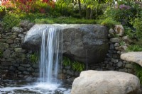 A waterfall and pool in naturalistic garden. Bible Society: The Psalm 23 Garden, Designer: Sarah Eberle, RHS Chelsea Flower Show 2021.