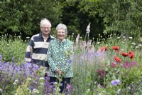 Couple standing in their wildflower meadow at North Cottage, Whittington - July