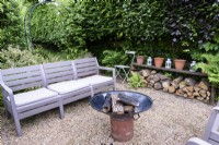 Seating area with fire bowl in a June garden