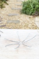 Wire frame for the nest lying on a wooden surface