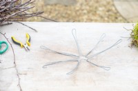 Wire frame for the nest lying on a wooden surface