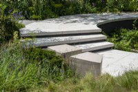 Curved steps leading to a path around a sunken garden.  The Cancer Research Legacy Garden, RHS Hampton Court Palace Garden Festival 2021