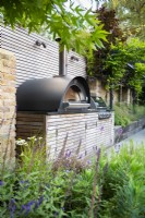 Bespoke outdoor kitchen unit with integrated pizza oven and bbq grill and BBQ.