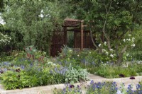 A pavilion crafted from metal screens is set into a formal layout incorporating rectangular herbaceous beds and trees such as Crataegus monogyna, common hawthorn, and Salix matsudana tortuosa, dragon's claw willow.