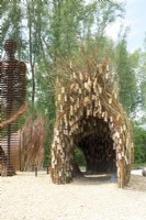 Arch made of willow branches with wooden wish plates made by nature artist Will Beckers.