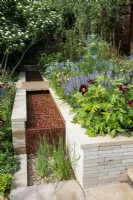 Water rill with laser cut willow pattern, clay paver raised bed with Paeonia 'Dark Eyes', Salvia 'Blue Hills', Verbascum and Geum - Morris  and  Co, RHS Chelsea Flower Show 2022 - Gold Medal