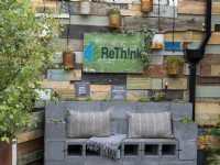 ReThink garden featuring reused items such as cans and wood with seating and a solar watering system