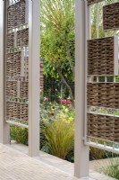 Pavilion with willow inserts gives a view through to border - The Stitcher's Garden, RHS Chelsea Flower Show 2022