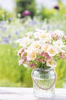 Bouquet containing Eschscholzia californica 'Peach Sorbet', Orlaya grandiflora and Limonium 'Apricot Beauty' in a glass container