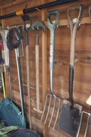 Interior of a well organised garden shed with various tools. Briar Cottage Garden. Devon NGS garden. Spring