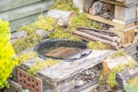 Water filled basin with a roof tile inside so wildlife can get in and out