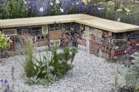 Bench made from gabions and housing bug hotels in Turfed Out at RHS Hampton Court Palace Garden Festival 2022