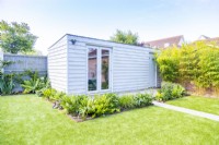 Large garden shed aurrounded by plant bedding