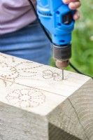 Woman drilling holes following the pattern