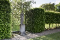 Statue of a classical female figure in a rose arbour at Doddington Hall near Lincoln in May