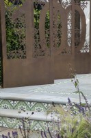 Decorative metal screens depicting the 100 years of the BBC in the Marshalls Landscaping Garden at BBC Gardeners World Live 2022
