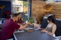Family gathered around table in secluded patio area