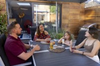 Family gathered around table in secluded patio area