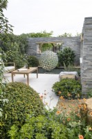 Seating area bordered by stone walls with windows in A Peaceful Escape at RHS Malvern Spring Festival 2022