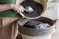 Mixing ingredients for a potting compost mixture, sieving the ingredients in to a bowl