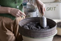 Mixing ingredients for a potting compost mixture, sieving the ingredients in to a bowl