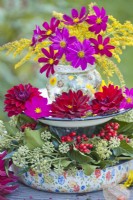 Display of late summer flowers on self made stand with cosmos, dahlia, ivy and rowan berries.