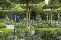 The Perennial Garden 'With Love'. Designer: Richard Myers. Formal garden with soft naturalistic planting in borders and beds. Plants include Digitalis purpurea f. albiflora, Saxifraga and Lupins and Carpinus betulis hedge. RHS Chelsea Flower Show 2022. Silver Medal.