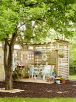 Patio with trellised walls, pergola, pavers and vintage table and chairs