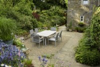 Courtyard garden with dining area at Cow Close Cottage, North Yorkshire in July