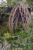 Laminated bamboo structure with swing overlooking a pond - The Guangzhou Garden, RHS Chelsea Flower Show 2021