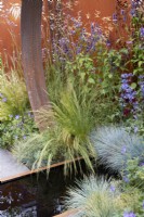 Corten steel garden feature with contemporary pool and mixed colourful planting. The Sunburst Garden. Design: Charlie Bloom and Simon Webster. RHS Hampton Court Garden Festival 2022.
